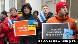 Um manifestante segura um cartaz com a inscrição "Alexei Navalny - o nosso presidente" em frente à embaixada russa em Tallinn, a 17 de março de 2024, durante as eleições presidenciais russas, 17 março 2024