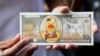 FILE - A protester shows a fake banknote depicting a duck during a pro-democracy rally demanding Thailand's king hands back royal assets to the people, reforms on monarchy, Bangkok, Nov. 25, 2020. 