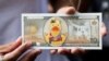 FILE - A protester shows a fake banknote depicting a duck during a pro-democracy rally demanding Thailand's king hands back royal assets to the people, reforms on monarchy, Bangkok, Nov. 25, 2020. 