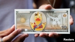 FILE - A protester shows a fake banknote depicting a duck during a pro-democracy rally demanding Thailand's king hands back royal assets to the people, reforms on monarchy, Bangkok, Nov. 25, 2020. 