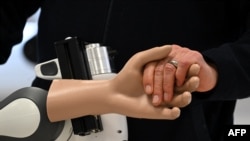 An employee holds the artificial hand of a doctor's workplace for remote diagnosis in the laboratory of the Research Center Geriatronics of the Technical University Munich, in Garmisch-Partenkirchen, southern Germany, March 6, 2023.