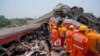 Tim penyelamat bekerja di lokasi kereta penumpang yang tergelincir di distrik Balasore, di negara bagian Orissa, India timur, Sabtu 3 Juni 2023.