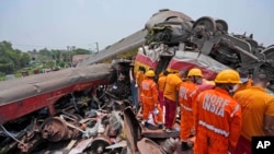 Tim penyelamat bekerja di lokasi kereta penumpang yang tergelincir di distrik Balasore, di negara bagian Orissa, India timur, Sabtu 3 Juni 2023.