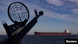 Un carguero pasa junto a una patrullera de la guardia costera de Ucrania en el mar Negro, en medio del ataque de Rusia a Ucrania, el 7 de febrero de 2024. REUTERS/Thomas Peter
