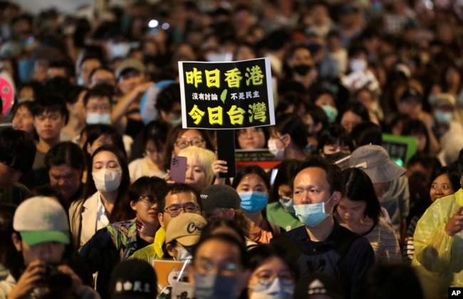 支持执政党民进党的民众聚集台湾立法院外，举着“昨日香港，今日台湾”的标语牌。(2024年5月28日)
