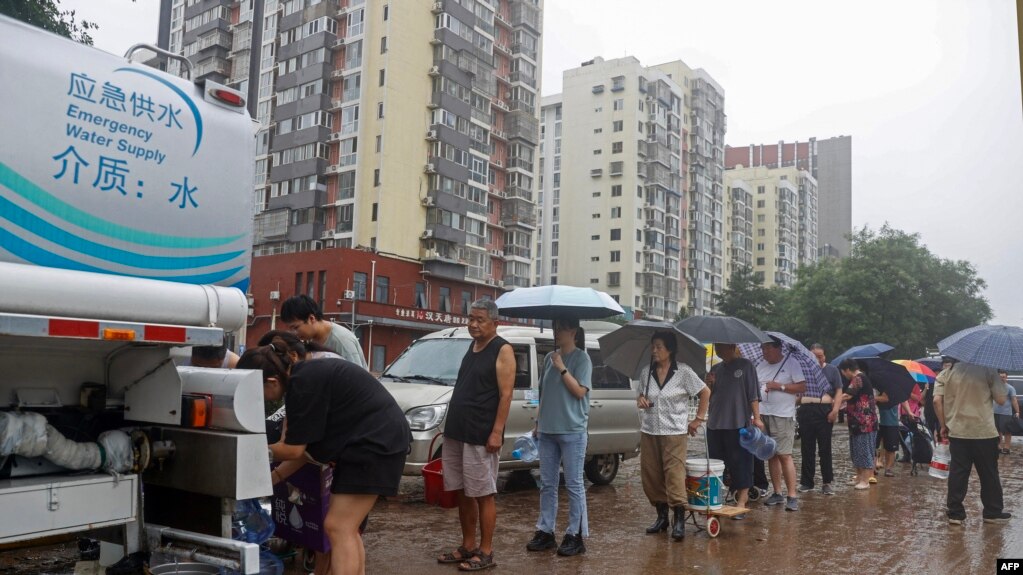 北京门头沟区遭洪水袭击供水系统被破坏后，居民排队领取清洁水。（2023年8月1日）(photo:VOA)