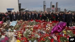 A group of ambassadors of foreign diplomatic missions attend a ceremony at a makeshift memorial in front of the Crocus City Hall on the western outskirts of Moscow, March 30, 2024.