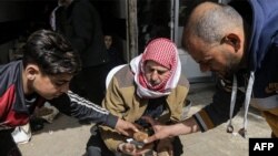 FILE - A youth hands a man a truffle at a merchant's stall in a market in the city of Hama in west-central Syria on March 6, 2023.