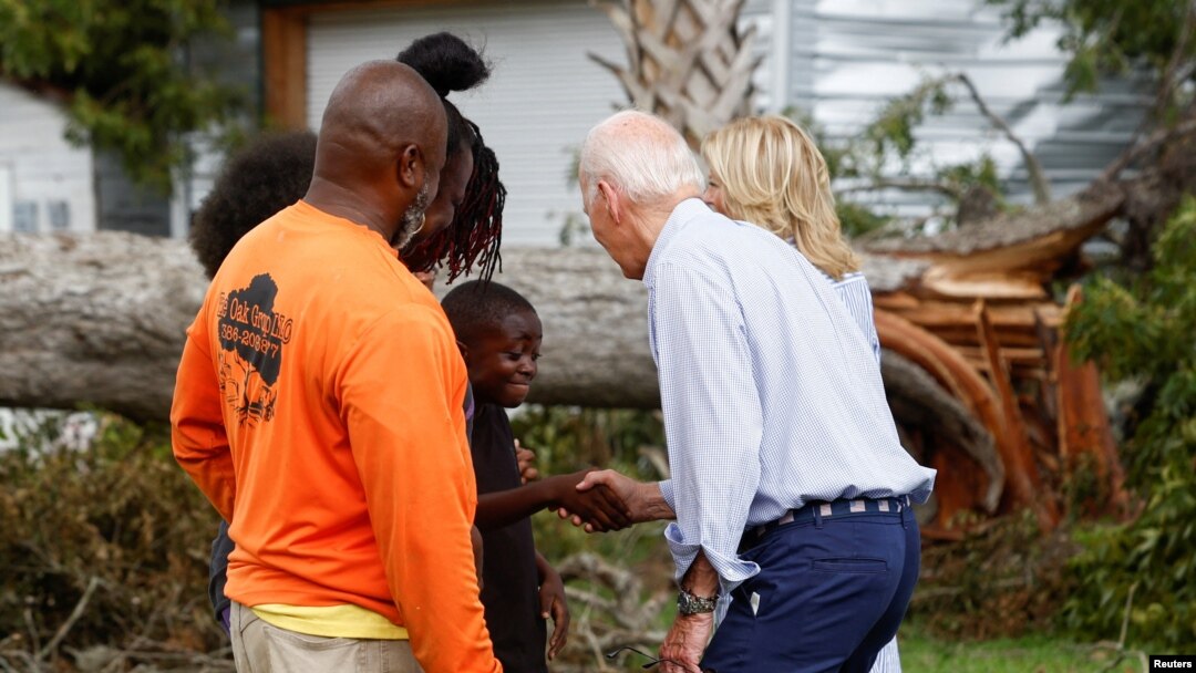 U.S. President Joe Biden shakes hands with a child, next to first lady Jill Biden, during their tour of Hurricane Idalia storm destruction, Live Oak, Florida, Sept. 2, 2023.