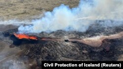 FILE - Lava spurts and flows after the eruption of a volcano in the Reykjanes Peninsula, Iceland, July 12, 2023, as seen in this photo taken from a Coast Guard helicopter.