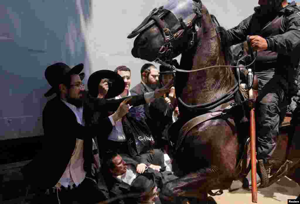 A protester clashes with an Israeli police officer on a horse during a demonstration against military conscription at Tel HaShomer recruitment base, in Ramat Gan.