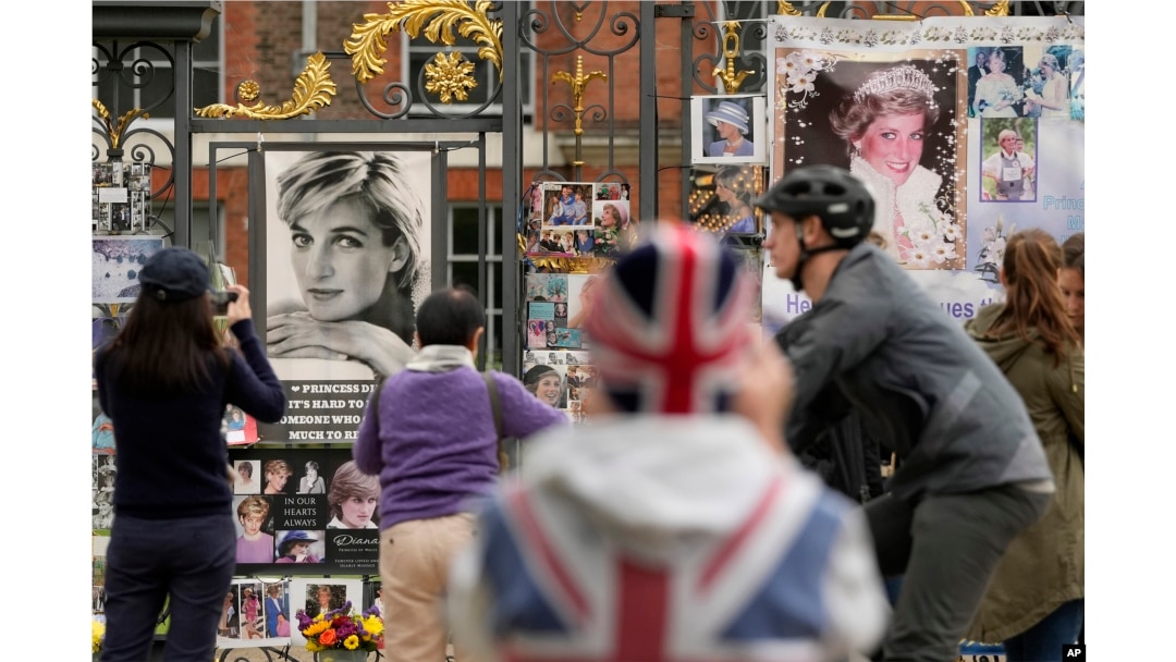 Orang-orang berdiri di depan foto Putri Diana di gerbang Istana Kensington di London, 31 Agustus 2023. (Foto: AP)