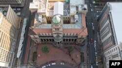 Des électeurs font la queue devant le bureau de vote de l'hôtel de ville de Johannesburg, le 29 mai 2024, lors des élections générales en Afrique du Sud.