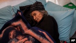 An elderly woman from the Teke family lies inside a tent at a camp for earthquake displaced people in Kahramanmaras, Turkey, Feb. 17, 2023.