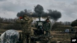 Украинские солдаты стреляют из гаубицы по российским позициям близ Бахмута, Украина, 7 марта 2023 года.
