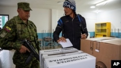 A voter looks at a soldier guarding the pools during in a snap presidential election in Quito, Aug. 20, 2023. The special election was called after President Guillermo Lasso dissolved the National Assembly by decree in May to avoid being impeached.