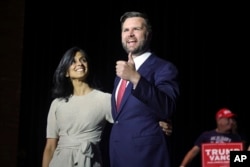 FILE - Calon wakil presiden dari Partai Republik Senator JD Vance, kanan, naik panggung bersama istrinya Usha Vance selama rapat umum di Middletown, Ohio, 22 Juli 2024. Banyak warga India Amerika, terlepas dari kecenderungan politiknya, gembira melihat Usha Vance menjadi pusat perhatian nasional.