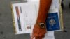 Un solicitante de visa estadounidense sostiene sus formularios del Departamento de Estado de Estados Unidos y su pasaporte cubano mientras espera en la fila frente a la entonces Sección de Intereses de EEUU -ahora embajada- en La Habana, el 1 de julio de 2015.