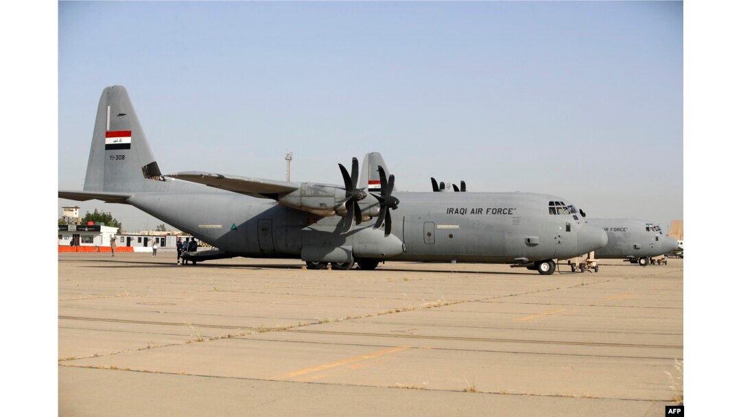 Petugas Irak berdiri di dekat pesawat Lockheed C-130 Hercules di Pangkalan Udara Muhammad Alaa, daerah kantong militer Bandara Internasional Baghdad, 24 April 2024, pada peringatan 93 tahun berdirinya angkatan udara Irak pada tahun 1931. (AHMAD AL-RUBAYE/AFP)