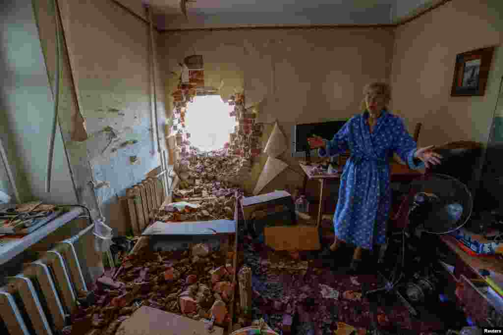 Local resident Viktoria Aksenova, 61, ezamines the damage and removes ruined objects inside her apartment, which was hit by shelling during of Russia-Ukraine conflict in Donetsk, Russian-controlled Ukraine.