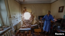 Local resident Viktoria Aksenova, 61, ezamines the damage and removes ruined objects inside her apartment, which was hit by shelling during of Russia-Ukraine conflict in Donetsk, Russian-controlled Ukraine.