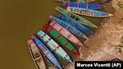 Boats sit on the bank of the Acre River, the main water source for the city of Rio Branco, which is facing water shortages amid a drought in Acre state, Brazil, Friday, Aug. 2, 2024. (AP Photo/Marcos Vicentti)