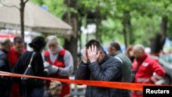 People react after a boy opened fire on other students and staff at a school in downtown Belgrade, Serbia.