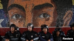 La policía antidisturbios se forma frente a un mural que representa al héroe de la independencia Simón Bolívar mientras los partidarios del presidente de Venezuela, Nicolás Maduro, marchan para defender los resultados de las elecciones, en Caracas, el 30 de julio de 2024. REUTERS