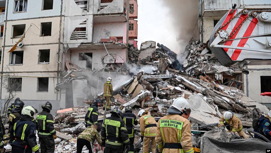 Foto yang dirilis oleh Gubernur wilayah Belgorod Vyacheslav Gladkov di media sosial pada 12 Mei 2024, menunjukkan pekerja darurat Rusia di luar blok apartemen yang sebagian runtuh setelah serangan rudal Ukraina, di kota Belgorod.