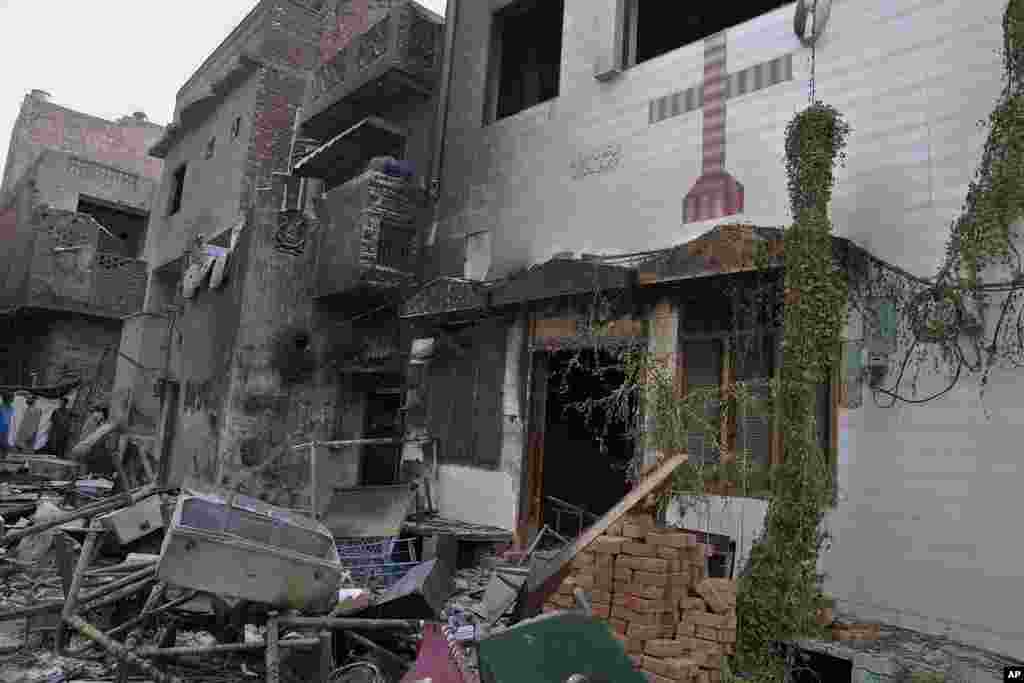 Local residents look at the rubble of homes and church vandalized by an angry Muslim mob in Faisalabad district, Pakistan, Aug. 17, 2023.