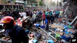 Warga berkumpul di luar lokasi pasca ledakan di sebuah gedung berlantai 7 di Dhaka, Bangladesh, Selasa, 7 Maret 2023 yang menewaskan sedikitnya 18 orang. 