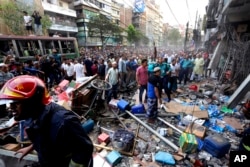 Onlookers gather outside the site of an explosion in a building in Dhaka, Bangladesh, March 7, 2023.