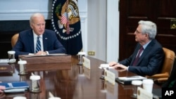 FILE - Attorney General Merrick Garland, right, listens as President Joe Biden speaks during a meeting in the Roosevelt Room of the White House, in Washington, Nov. 21, 2023.