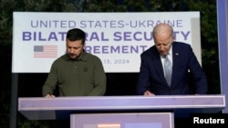 13일 이탈리아 파사노에서 조 바이든 미국 대통령과 이날 볼로디미르 젤렌스키 우크라이나 대통령이 새로운 안보협정에 서명하고 있다.