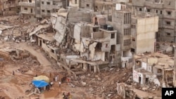 Rescuers and relatives of victims set up tents in front of collapsed buildings in Derna, Libya, Sept. 18, 2023.