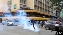 A demonstrator kicks back a tear gas canister during a protest against proposed tax hikes in a finance bill that is due to be tabled in parliament in Nairobi, Kenya, June 18, 2024.