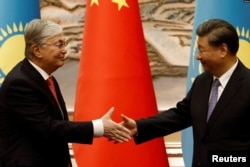 中國國家主席習近平(右)和哈薩克總統卡西姆-佐馬爾·托卡耶夫在中國西安舉行的中國-中亞峰會之前的簽字儀式上握手