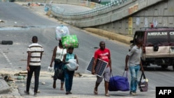 People flee an area where gang violence occurred in Port-au-Prince, Haiti, on April 26, 2024. 