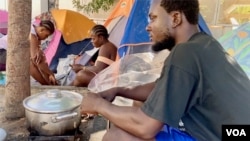 Joseph Milk from Liberia prepares a meal with his fellow migrants in Tunis. (Lisa Bryant/VOA)