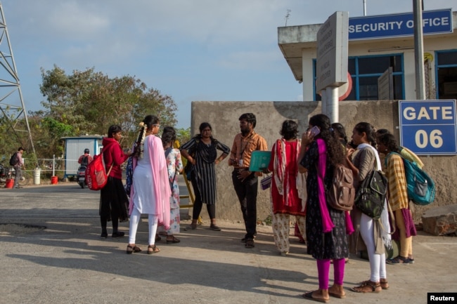 FILE - Job aspirants talk with a hiring agent outside the Foxconn factory, where workers assemble iPhones for Apple in Sriperumbudur near Chennai, India, April 1, 2024.