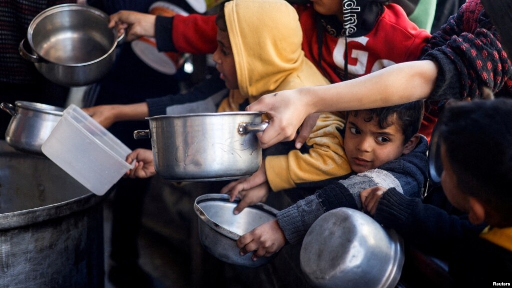 Anak-anak Palestina antre untuk menerima bantuan makanan yang dimasak oleh dapur amal di tengah kekurangan pasokan makanan di Rafah, di Jalur Gaza selatan (foto: dok).