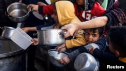 ARCHIVO - Niños palestinos esperan para recibir comida elaborada por una cocina de caridad en medio de la escasez de suministros de alimentos en Rafah, en el sur de la Franja de Gaza, el 5 de marzo de 2024.