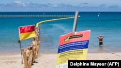 Sejumlah papan peringatan bahaya serangan hiu dan jaring penghalang dipasang di sepanjang pantai Baie des Citrons di Noumea, Kaledonia Baru, 6 Desember 2023. (Foto: Delphine Mayeur/AFP)