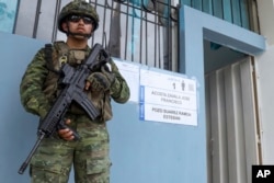 Un soldado vigila un n puesto de votación durante el referéndum propuesto por el presidente Daniel Noboa para respaldar nuevas medidas de seguridad destinadas a combatir las bandas criminales, en Olón, Ecuador, el domingo 21 de abril de 2024.