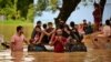 Floods triggered by torrential rains have swamped a swath of low-lying Bangladesh. People wade through flood waters in Feni, Bangladesh, Aug. 23, 2024. 