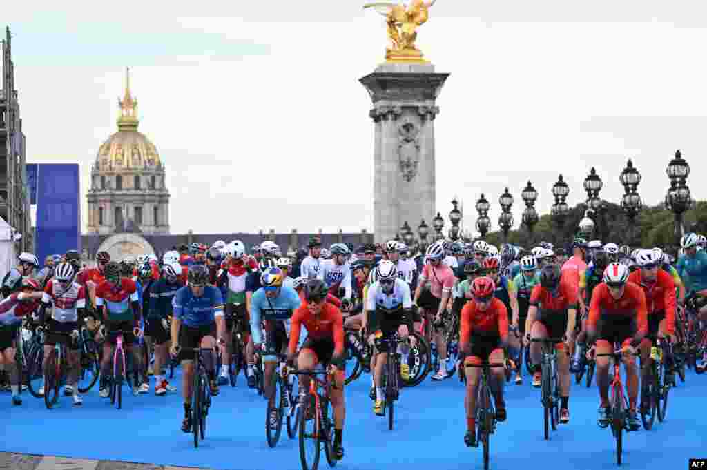 Triathlon athletes on their bikes take to the start at the Alexander III Bridge on the eve of planned triathlon test races, in Paris, France.