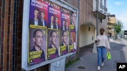 A woman walks past campaign posters for the upcoming European election in Colombes, west of Paris, June 6, 2024.