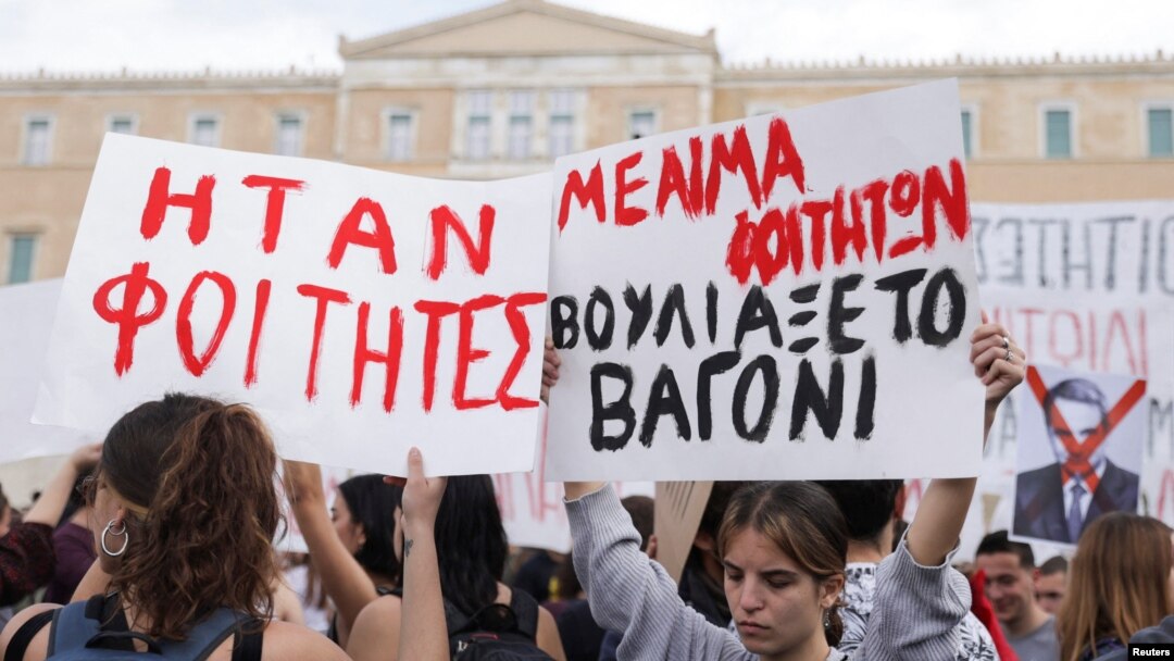 Protesters hold banners during a demonstration in front of the parliament building, following the fatal collision of two trains, in Athens, March 12, 2023. The banners read 'They were students. The train car sank with students' blood.'