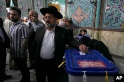 Religious leader of the Iranian Jews Younes Hamami Lalehzar casts his ballot during the presidential election at a polling station in Tehran, June 28, 2024.