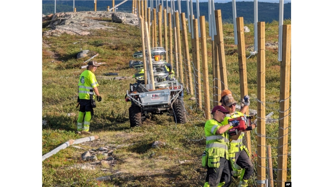 People work to build a new fence along the border with Russia, next to Storskog, Norway, Aug. 23, 2023.